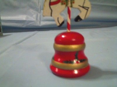 This WOOD WOODEN CAROUSEL HORSE ON RED BELL CHRISTMAS ORNAMENT MADE IN 